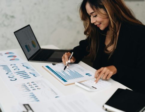 usiness analyzing investment charts with calculator laptop. Accounting and technology in office